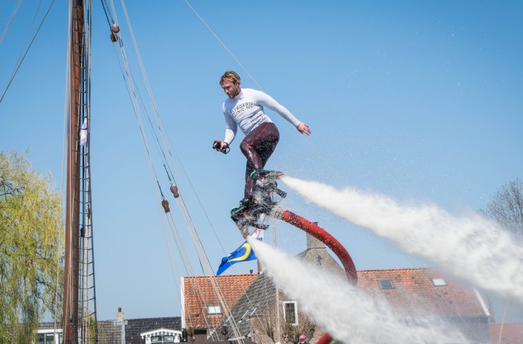 Flyboarder zweeft boven het water aan de Tsjamkedykje in Balk, voortgestuwd door een waterjet.